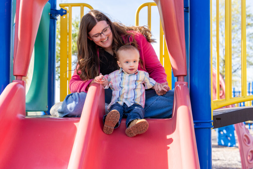 Woman helping child on slide