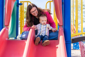 Woman helping child on slide