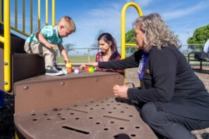 Boy and two women on playground equipment