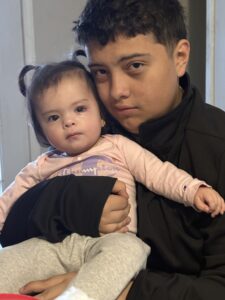Yuliana is held by her big brother.